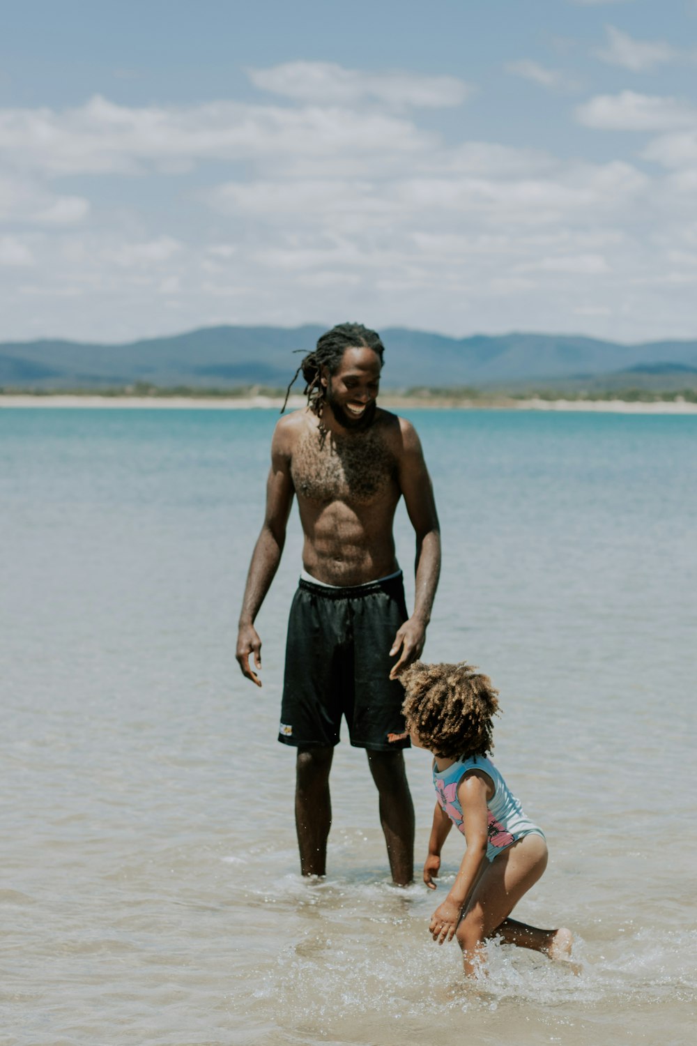 a man and a little girl playing in the water
