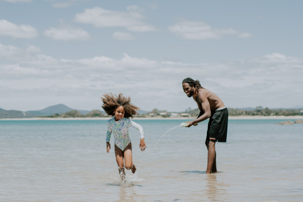 a man and a little girl playing in the water