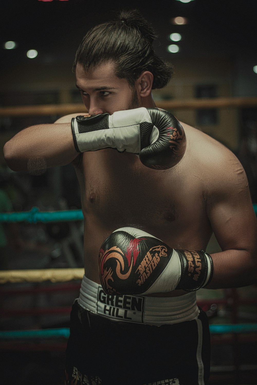 a man wearing boxing gloves standing in a boxing ring