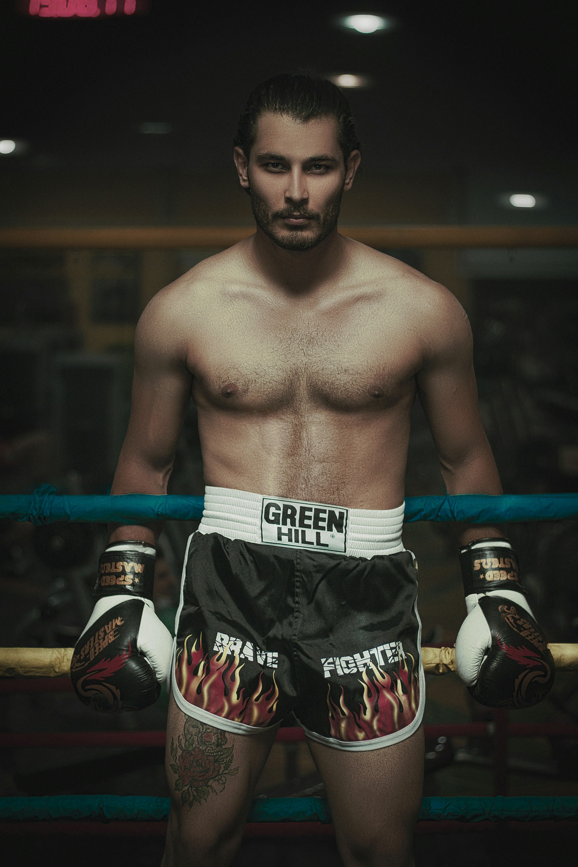Professional boxer Dmitri Volkov in photoshoot session, boxing gloves raised, dramatic studio lighting