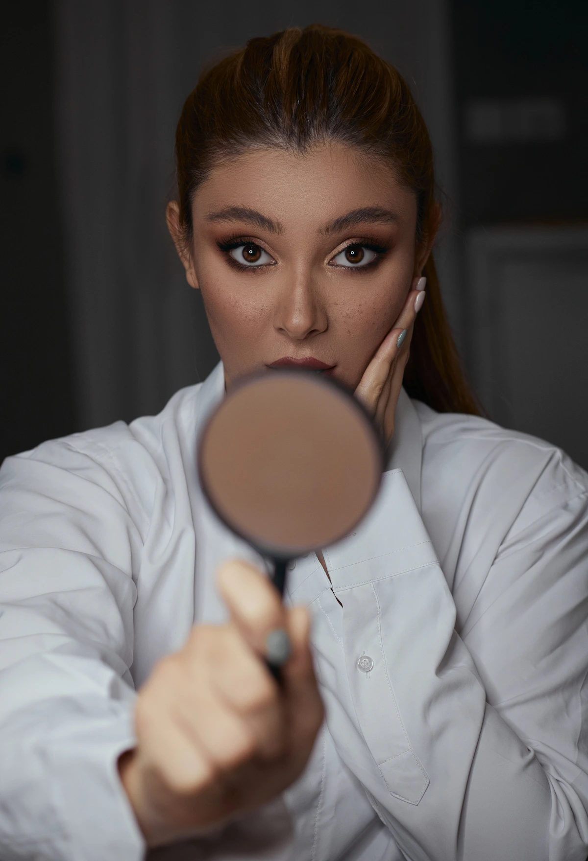 Woman looking through a magnifying glass, representing personalised skin assessment