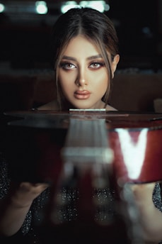a woman sitting at a table with a guitar in front of her