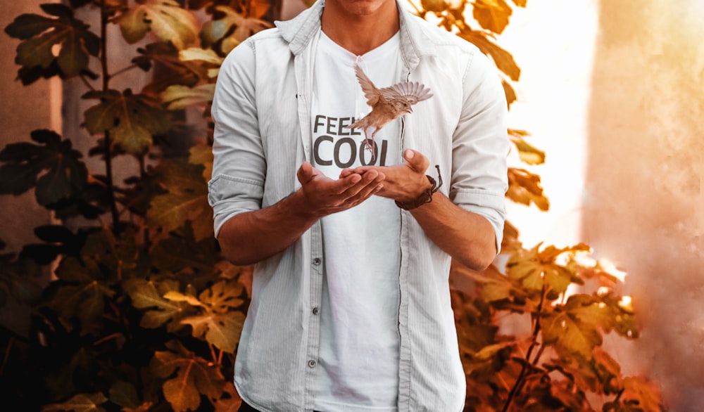 a man is holding a leaf in his hands