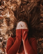 a woman laying on top of a pile of leaves