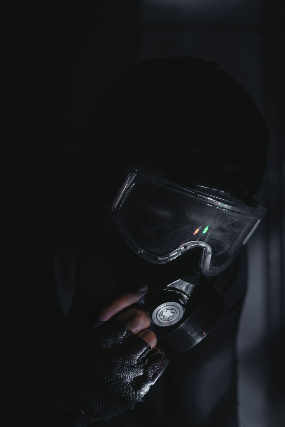 a person in a dark room wearing a mask and holding a camera