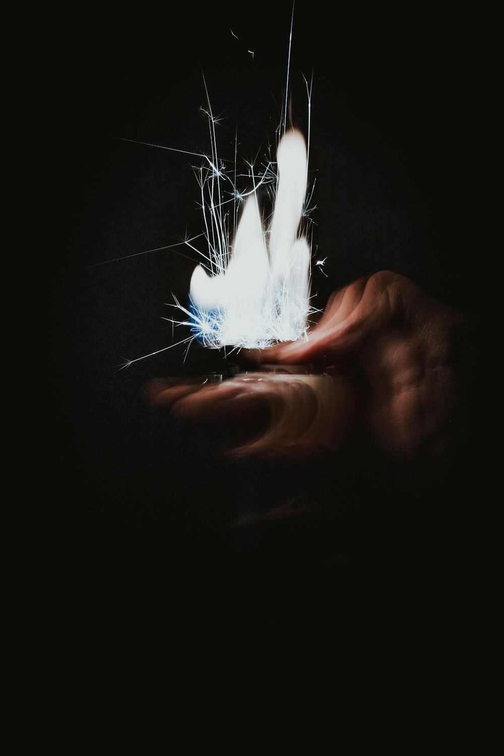 a person holding something in their hand in the dark