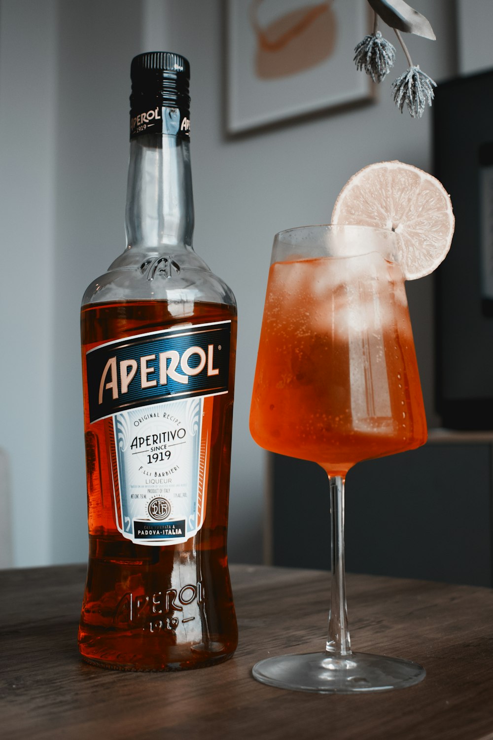 a bottle of aperol next to a glass of alcohol