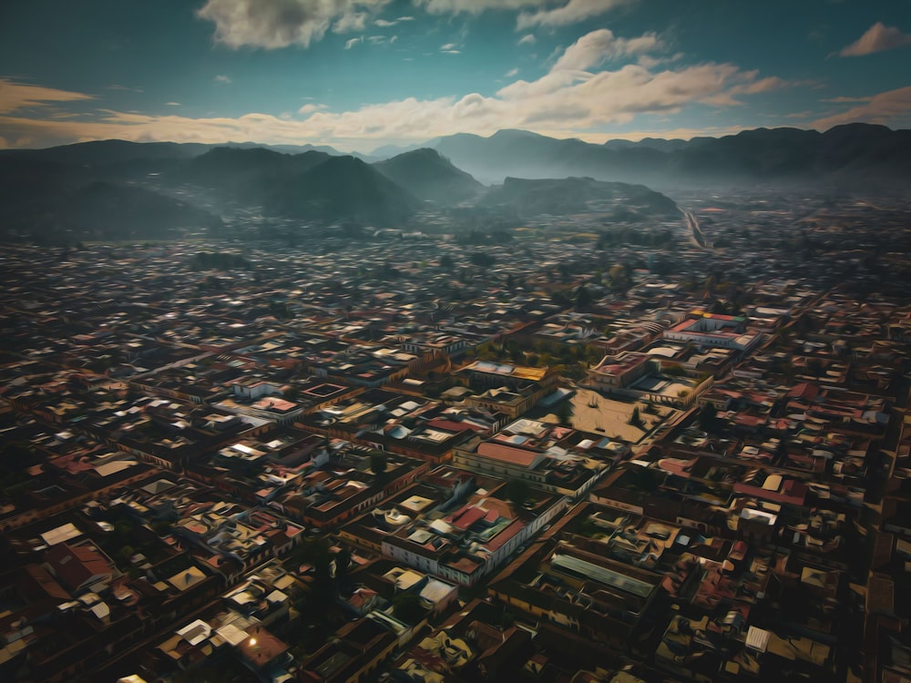 an aerial view of a city with mountains in the background