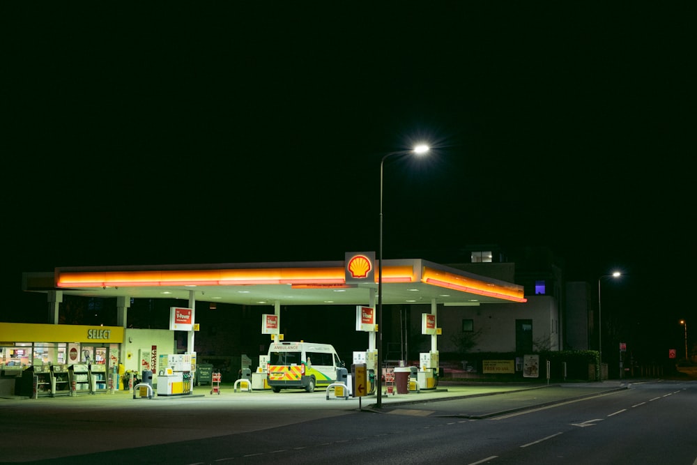 a gas station at night with a lit up gas station