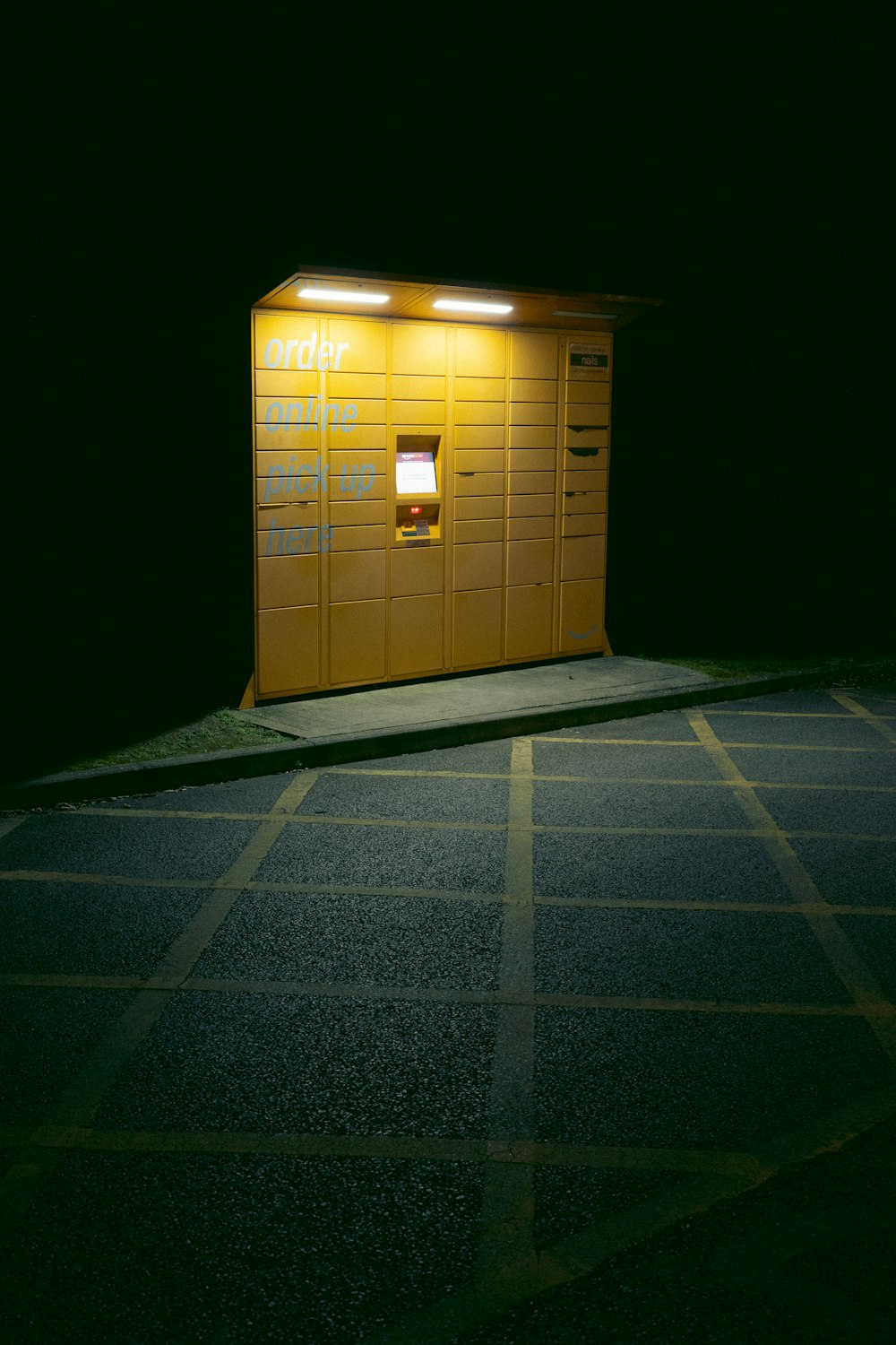 a yellow phone booth sitting in the middle of a parking lot