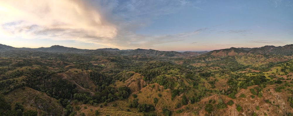 an aerial view of a mountain range with a cloudy sky