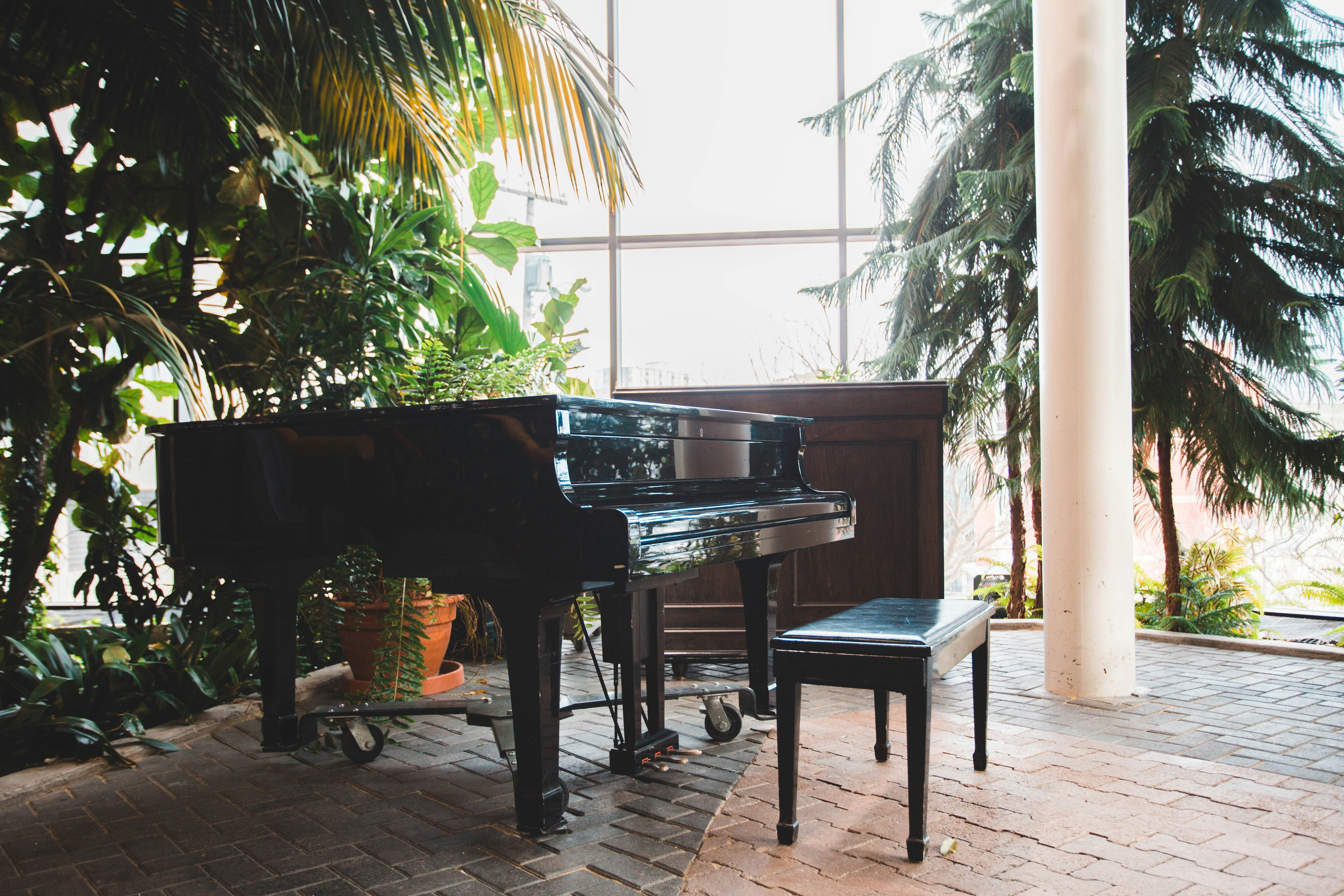 a black piano sitting on top of a brick floor