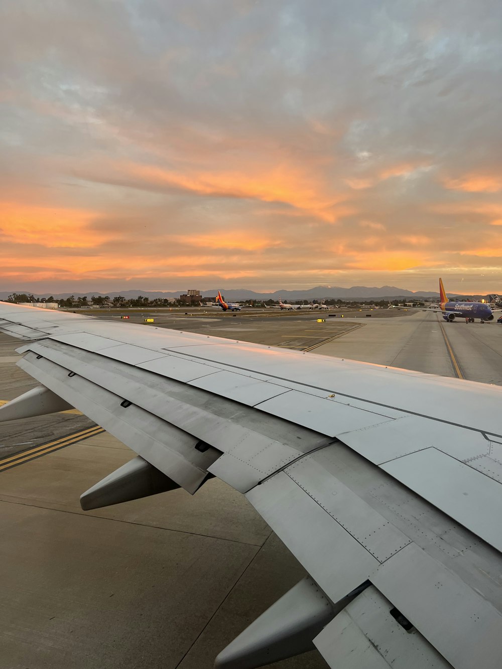 the wing of an airplane as the sun sets