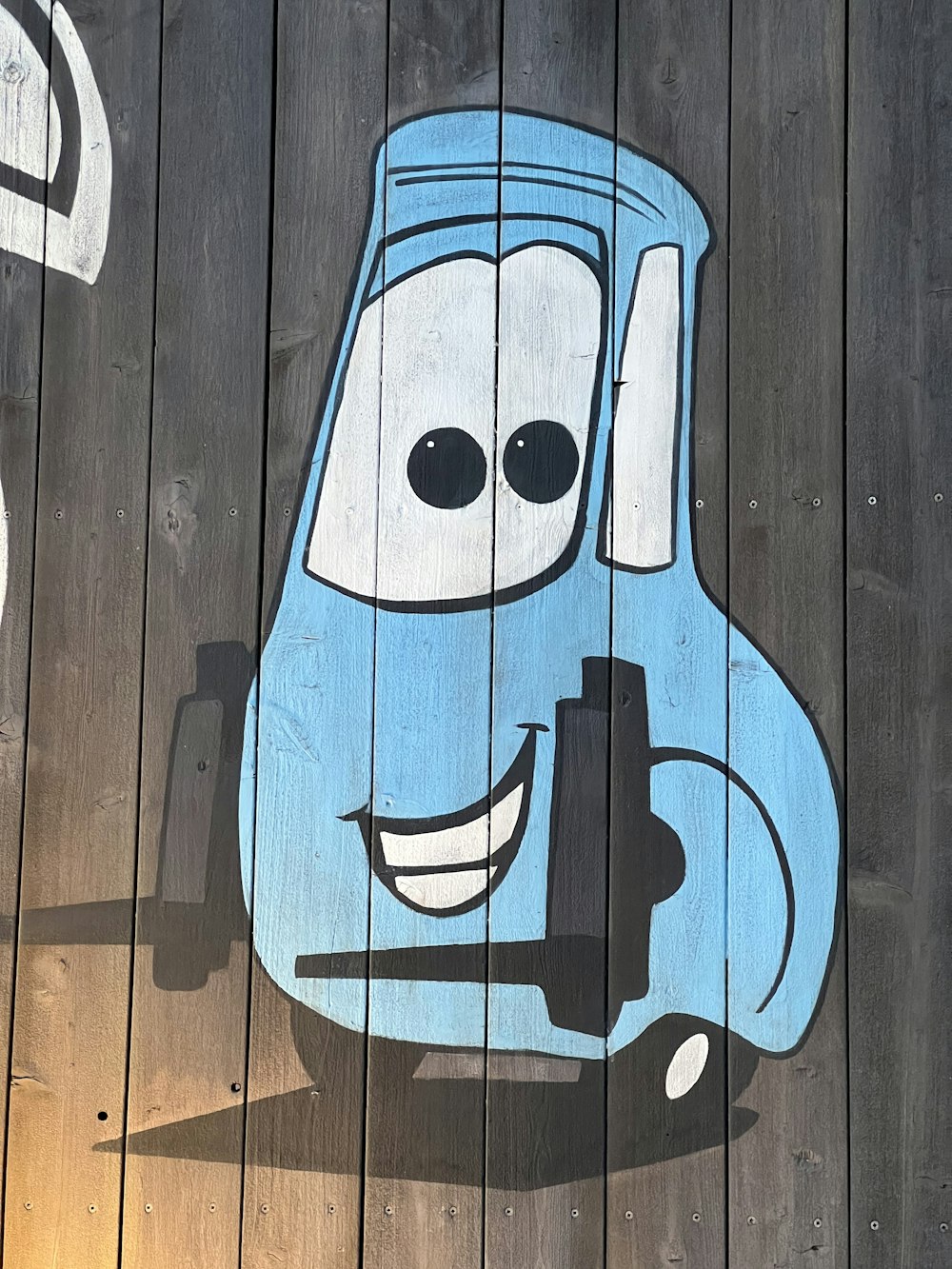 a picture of a cartoon character painted on a wooden fence