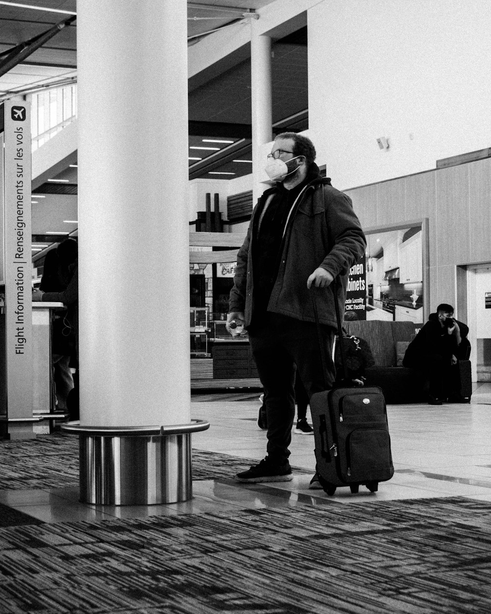 a man with a face mask is pulling a suitcase