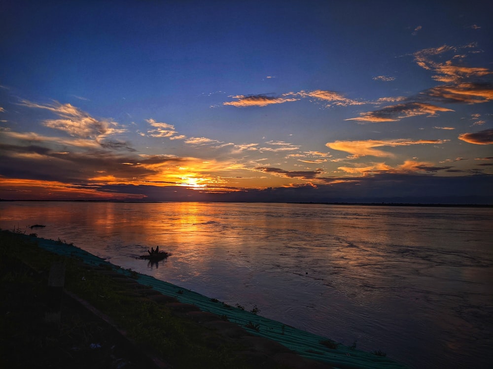 the sun is setting over a body of water