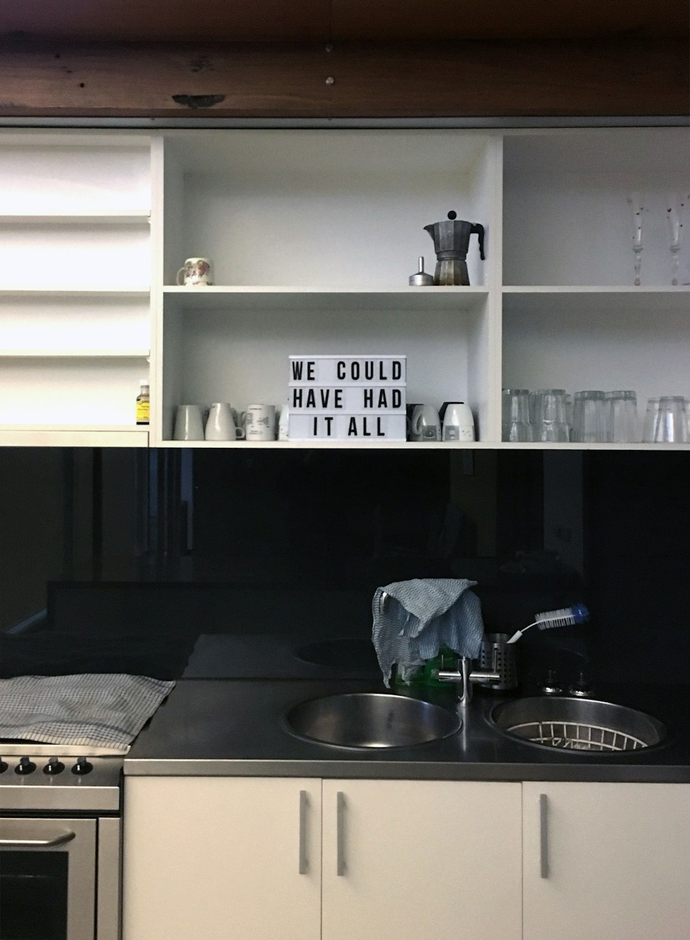 uma cozinha com armários brancos e bancadas pretas