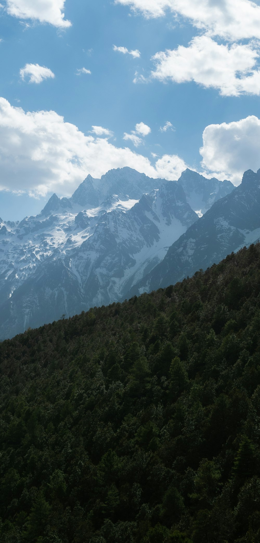 a view of a mountain range with trees and mountains in the background