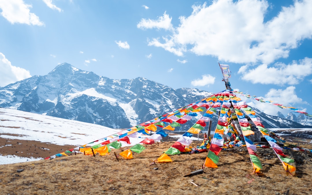 a group of colorful flags on top of a snow covered mountain, nice take