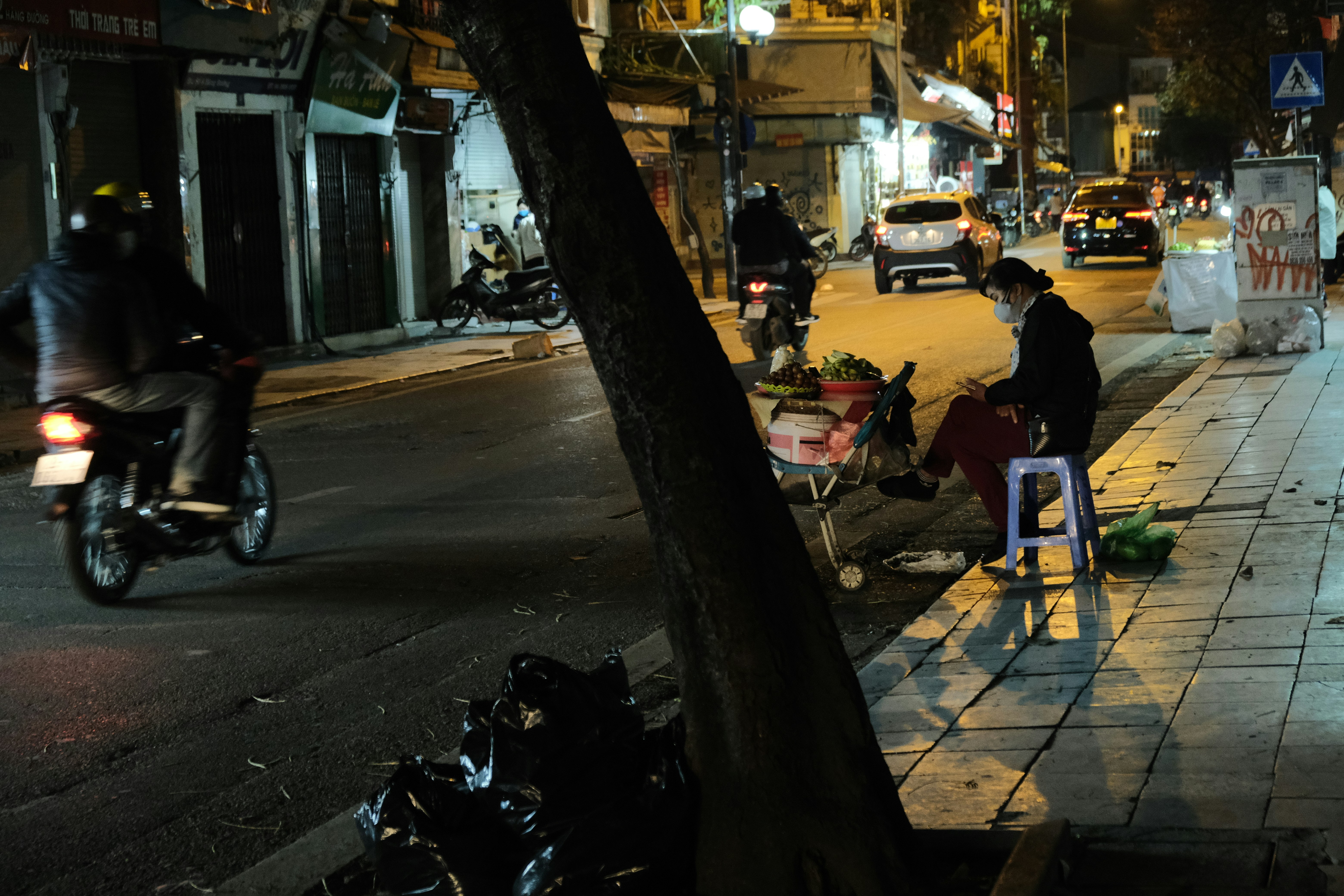 a person sitting on a chair on the side of a street