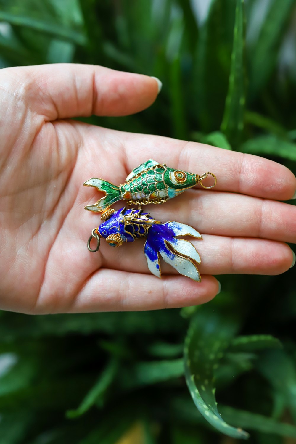 a person is holding some colorful brooches in their hand