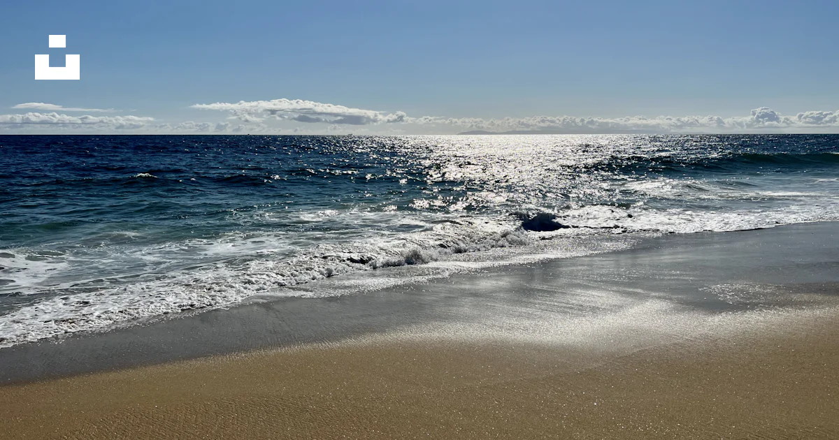 Une plage de sable avec des vagues qui arrivent sur le rivage photo ...