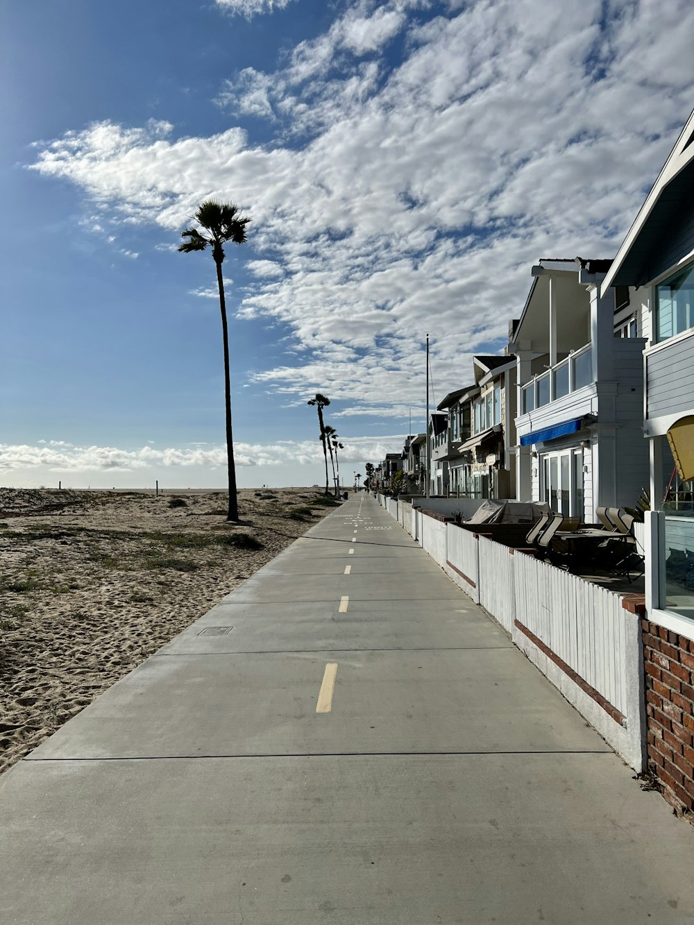 a street lined with beach houses and palm trees