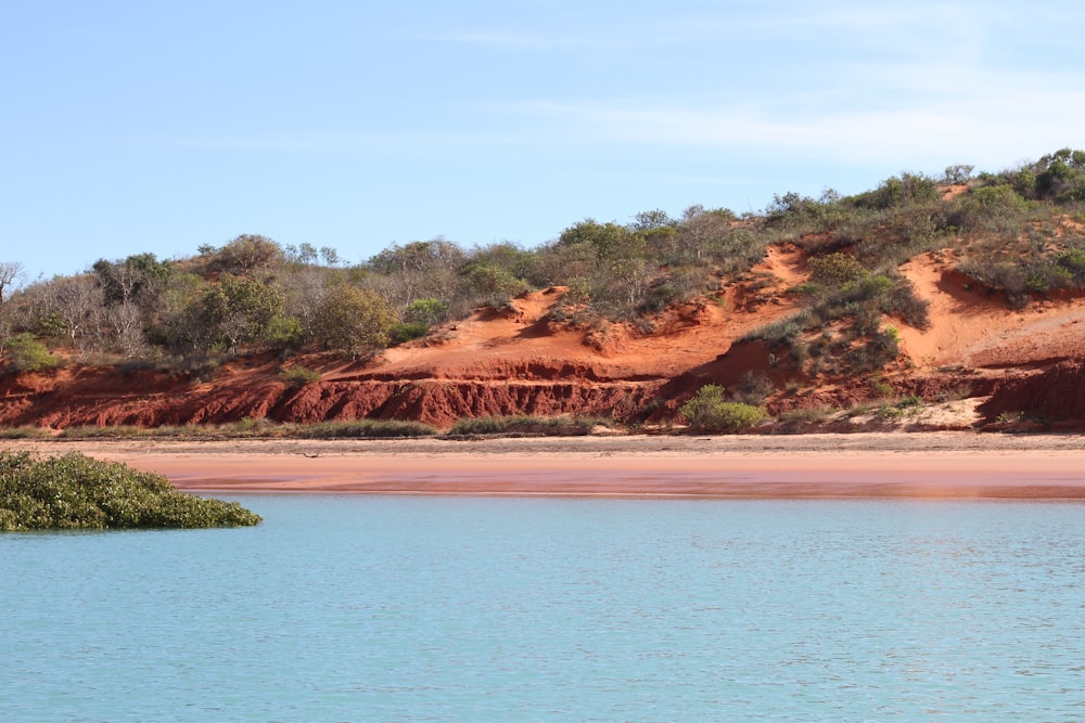 a body of water with a hill in the background