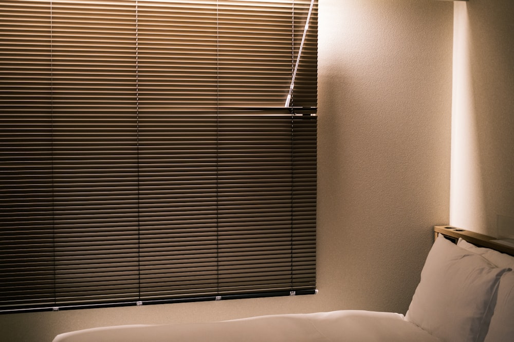 a bedroom with a bed and a window with blinds