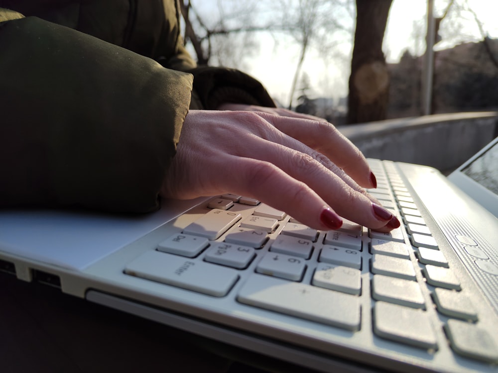 a woman's hand on a laptop keyboard
