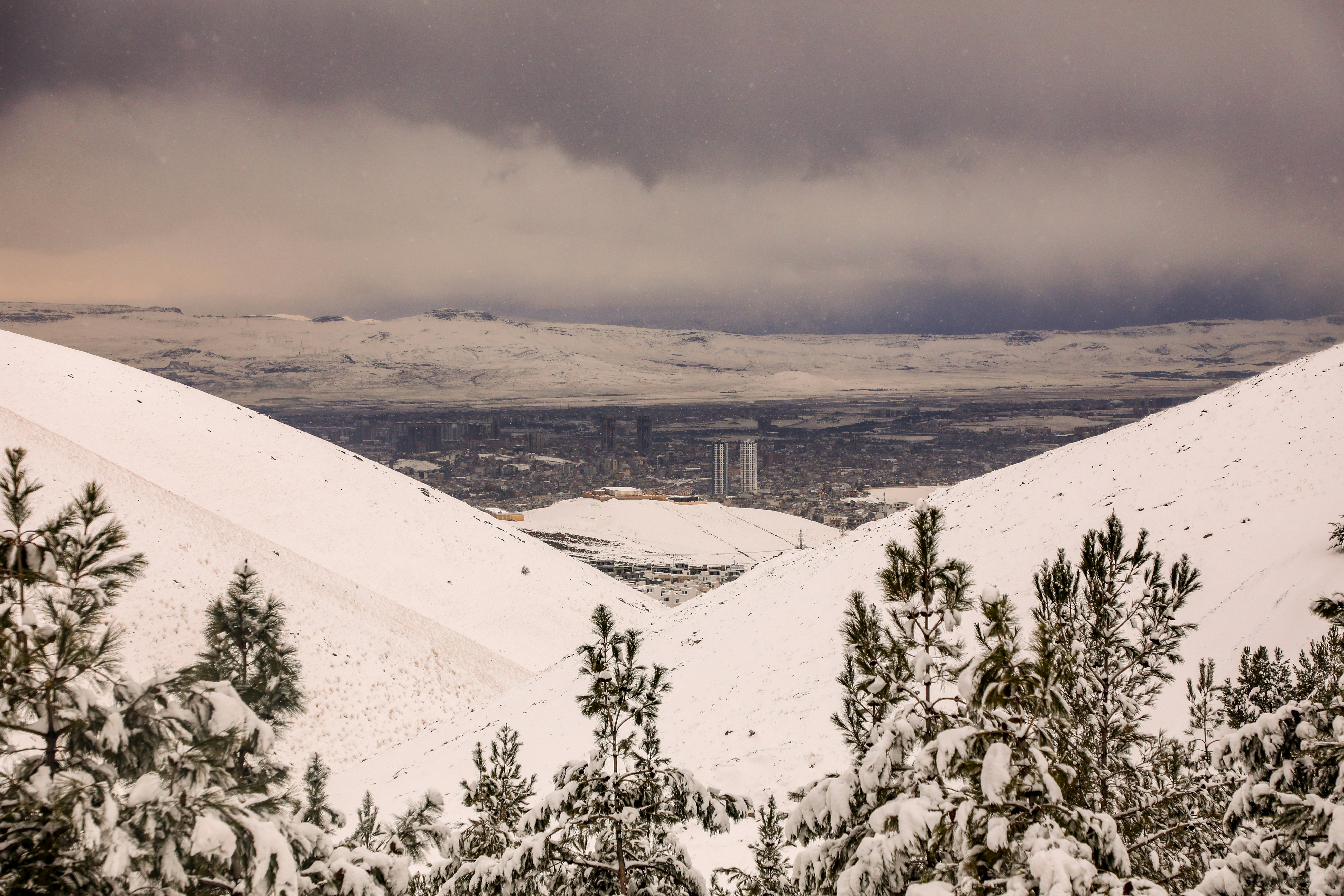 A view of a city from a hill covered in snow photo – Free Snow Image on ...