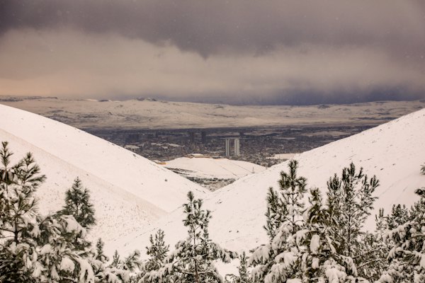 A view of a city from a hill covered in snow — Sulaymaniyah, Iraq