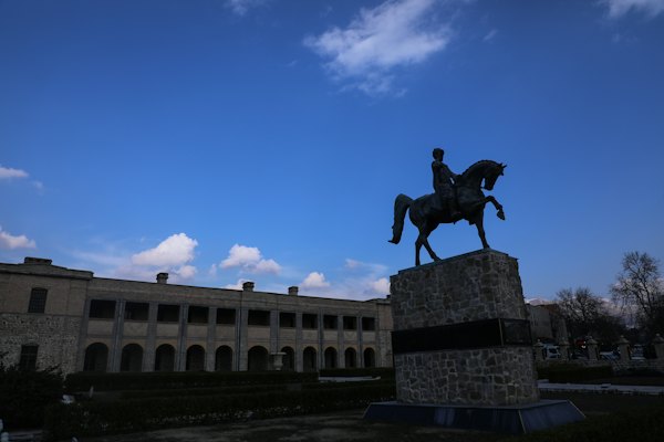 A statue of a man riding a horse in front of a building — Sulaymaniyah, Iraq