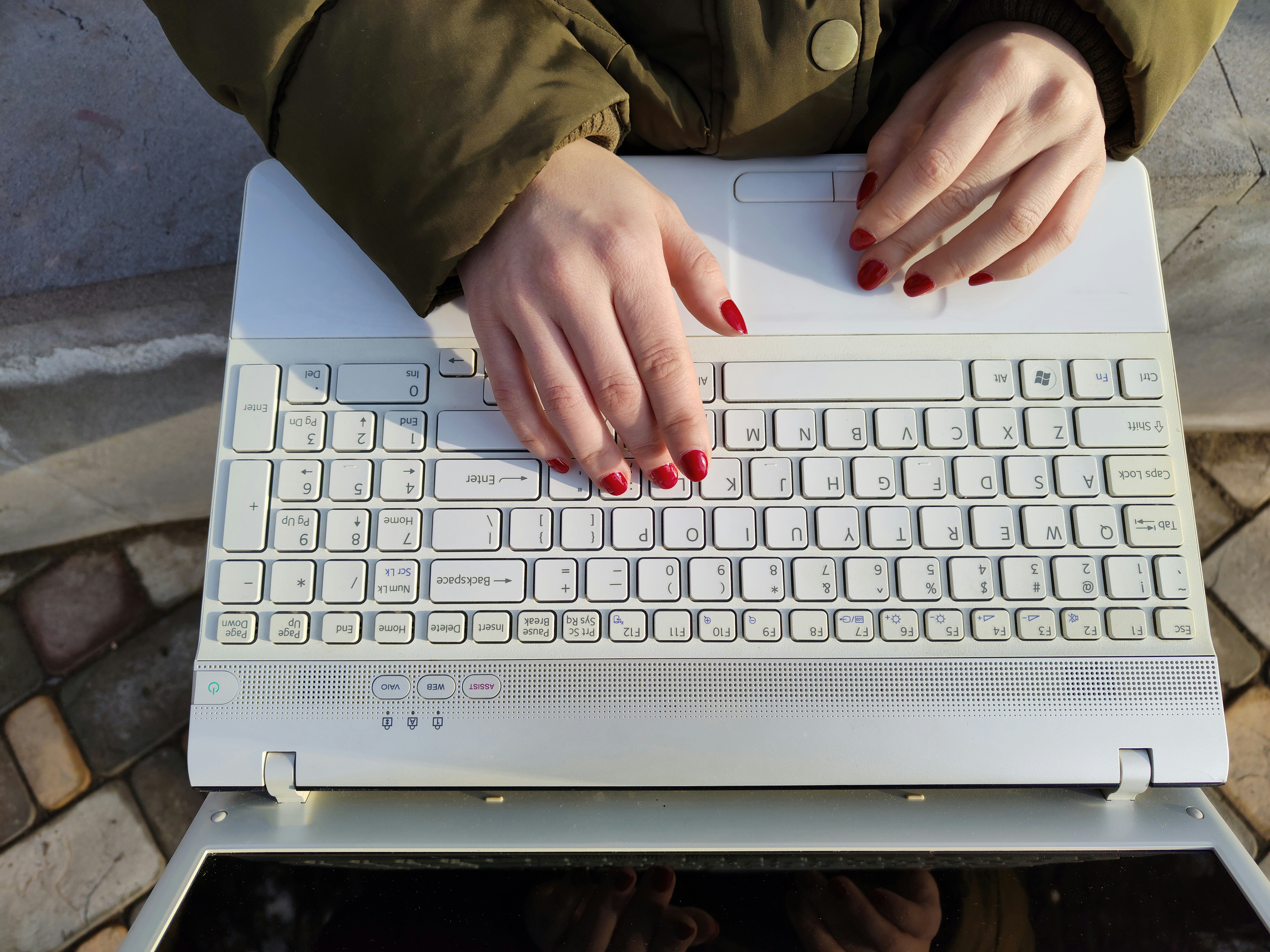 a woman is typing on a white keyboard