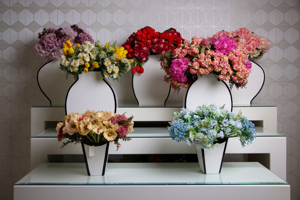 a bunch of flowers that are sitting in vases