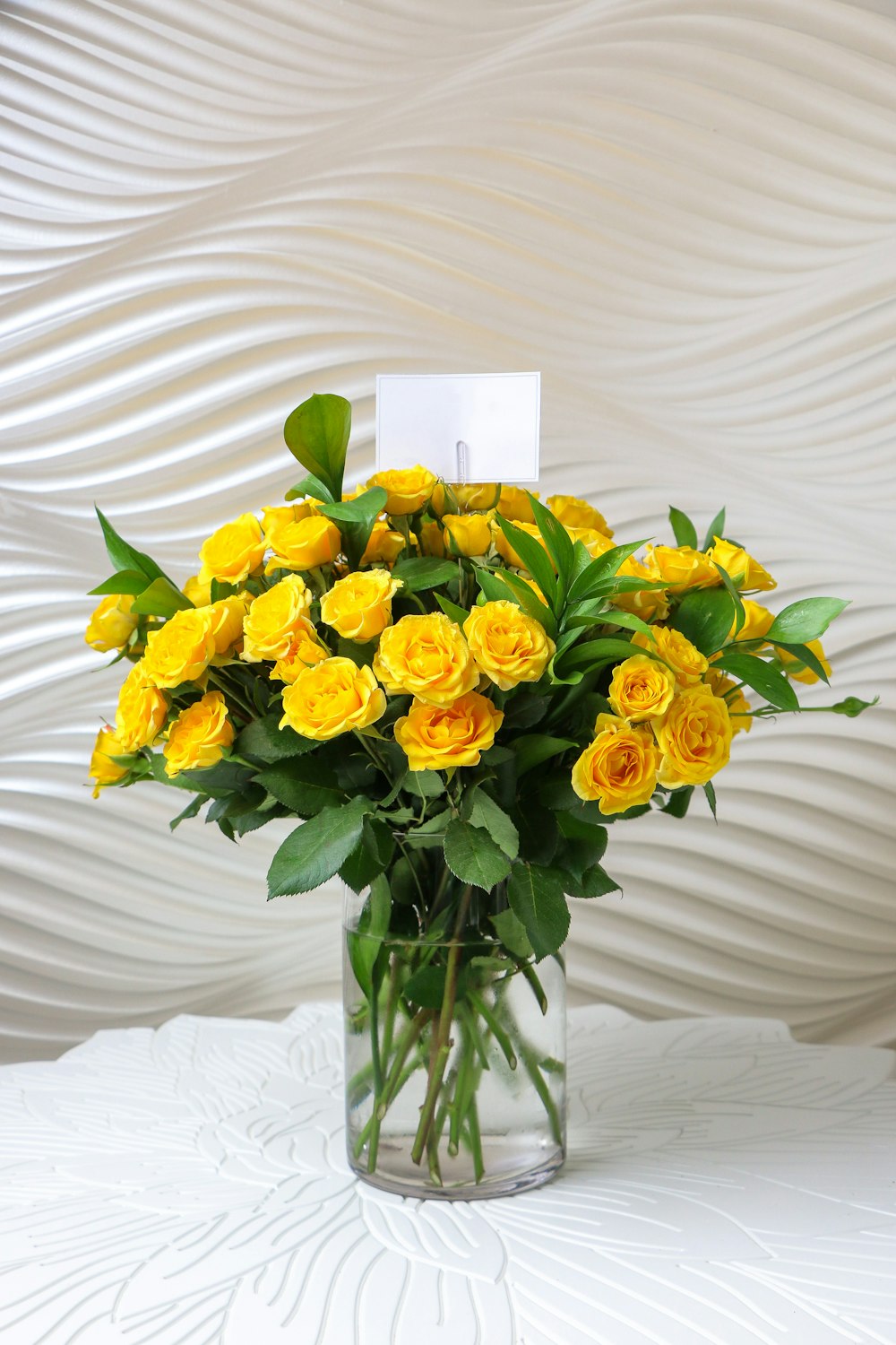 a vase filled with yellow roses on top of a table