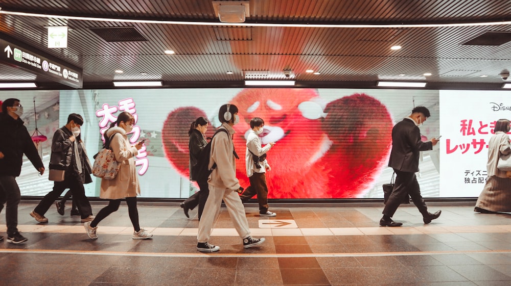 a group of people walking across a train station