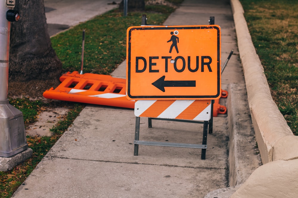 a detour sign sitting on the side of a road