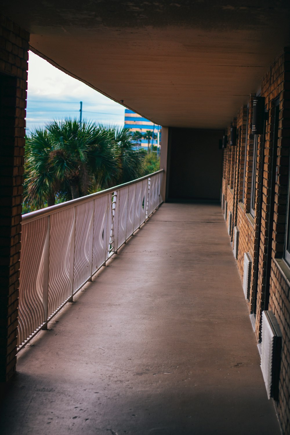 a long hallway with a railing and a clock on the wall