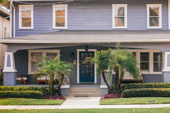 a blue house with palm trees in front of it