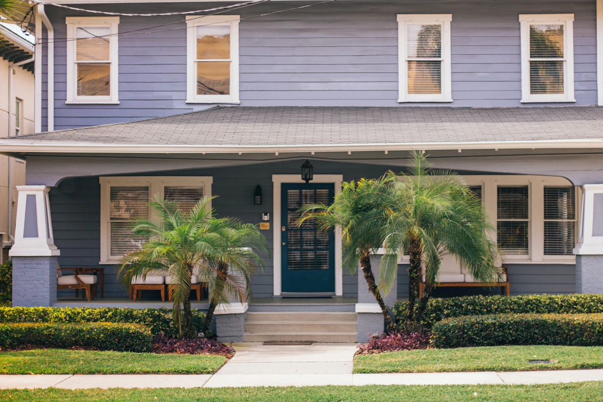 Blue Florida home with palm trees along the front walk