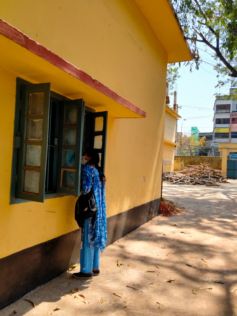 a woman standing in front of a yellow building