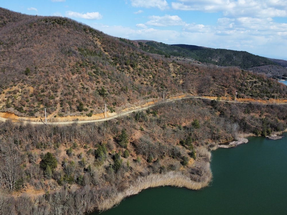 an aerial view of a winding road near a lake