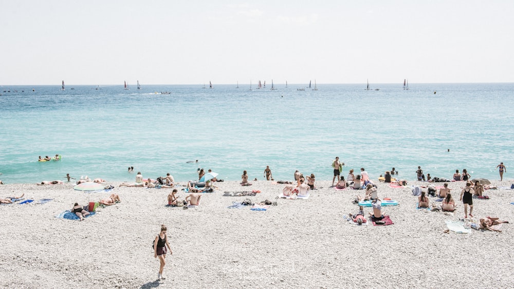 a group of people on a beach near the ocean