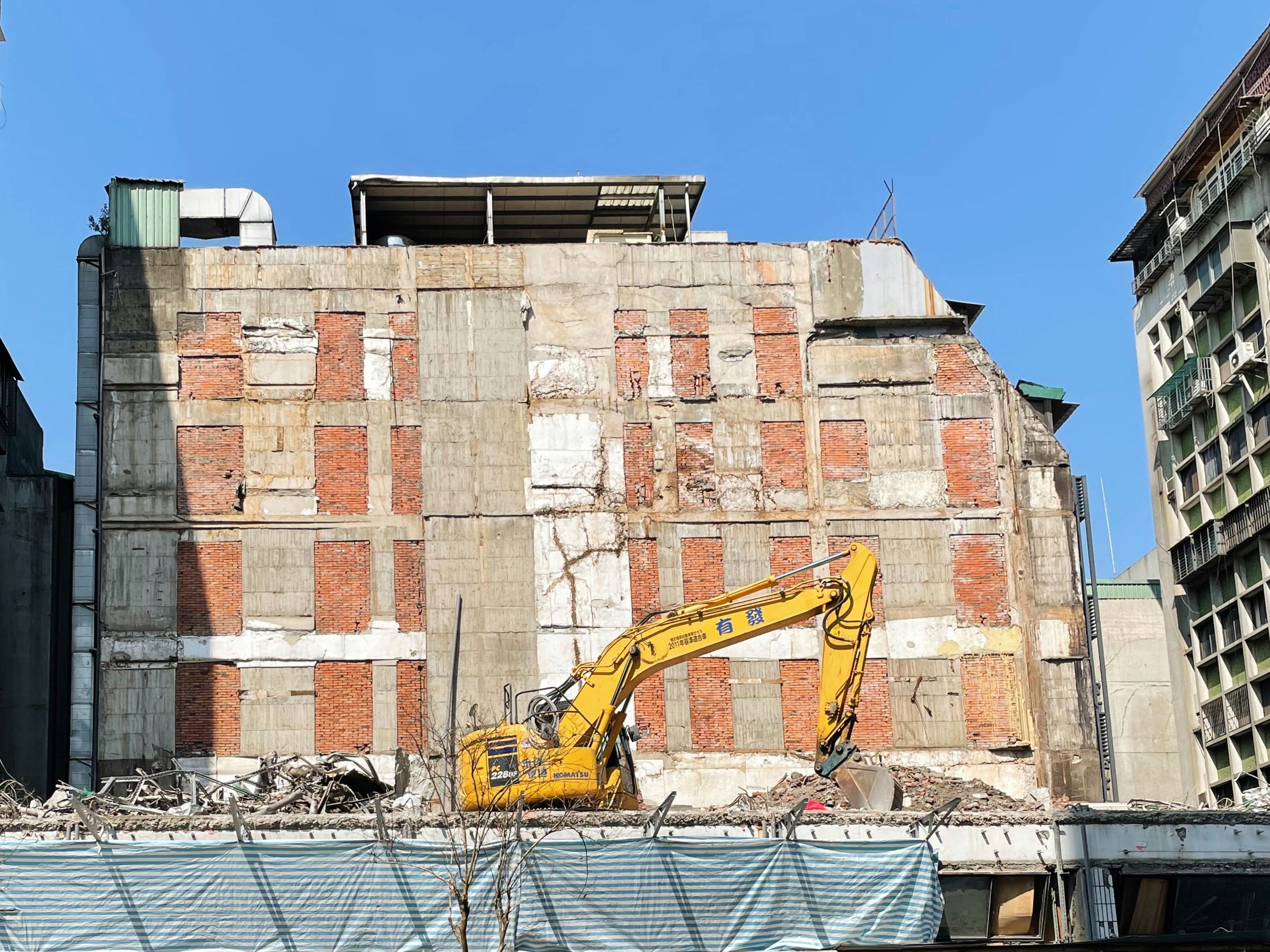 a construction site with a yellow excavator in the foreground