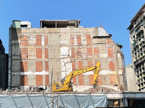 a construction site with a yellow excavator in the foreground