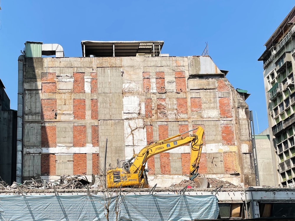 a construction site with a yellow excavator in the foreground