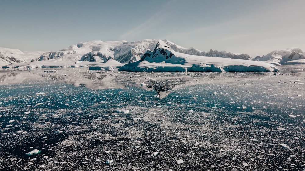 a large body of water surrounded by snow covered mountains