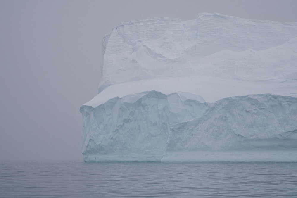 a large iceberg floating on top of a body of water