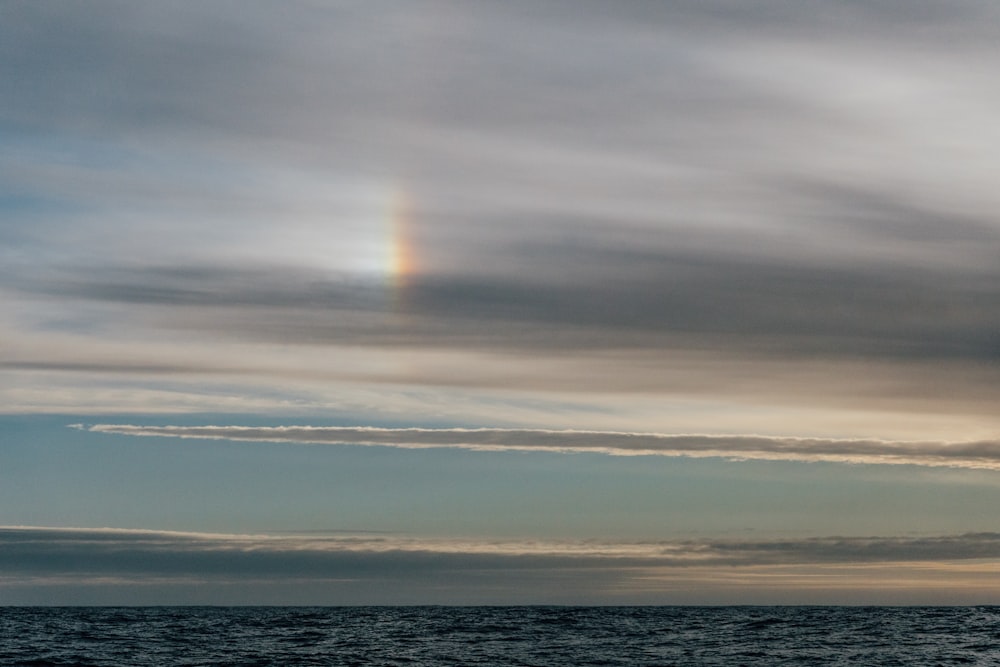 a rainbow in the sky over a body of water